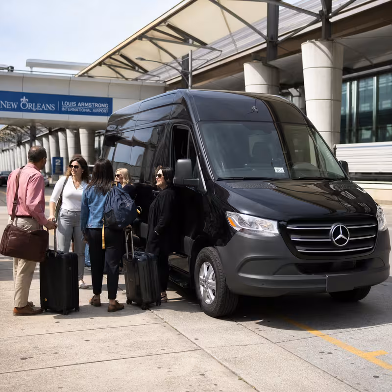 Group boarding a white charter bus for Airport Transportation transportation in New Orleans