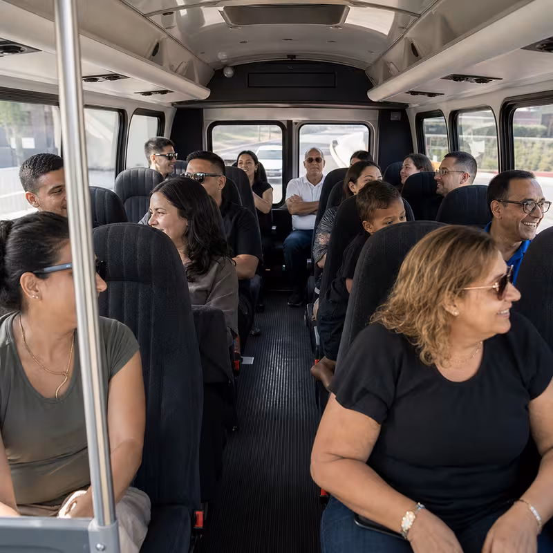 Group boarding a white charter bus for Private Event Transportation transportation in New Orleans